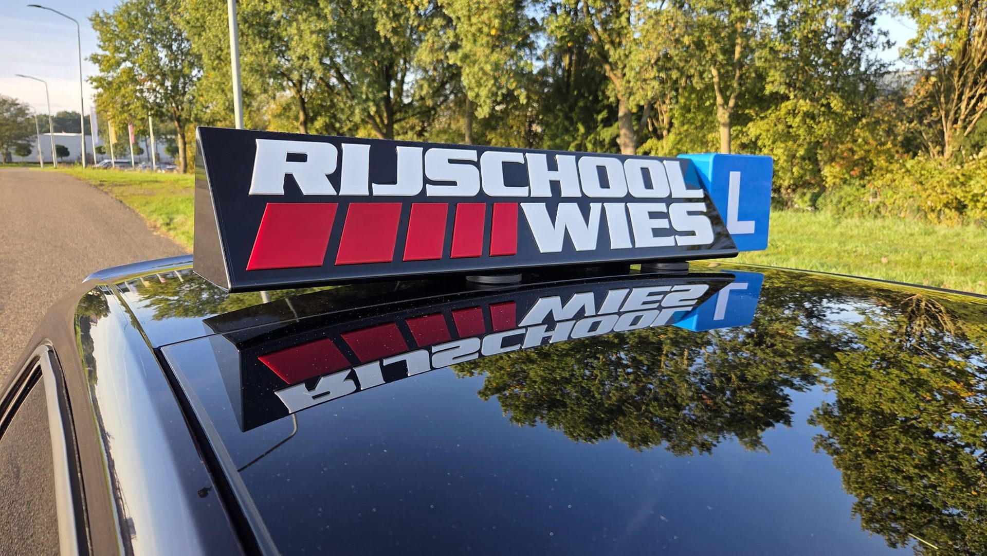 Het Rijschool Wies dakbord op de lesauto