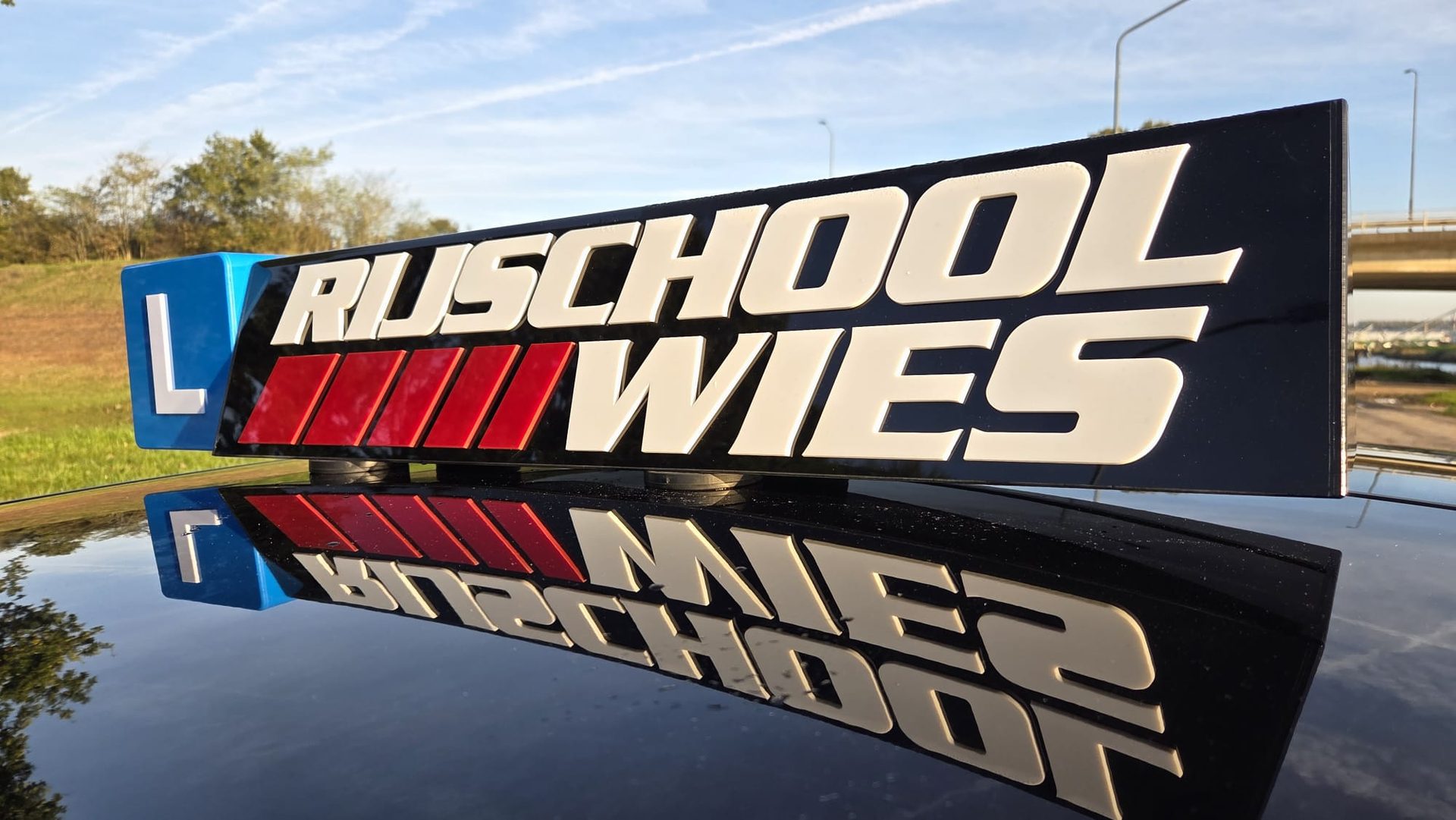 Het dakbord van Rijschool Wies met L-bord